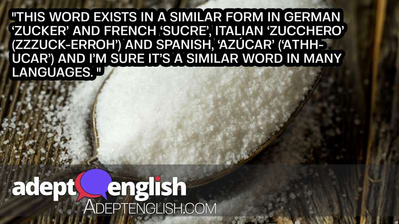 A photograph of a spoon full of white sugar. Used to help explain the origin of the English word sugar