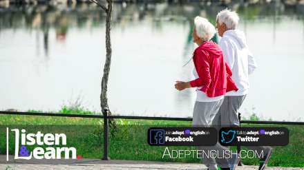 A side view full length portrait photograph of active senior couple running in park along lake. As we talk about longevity in our English lesson today.