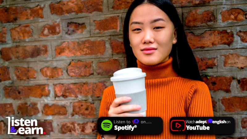 A young woman drinking a large coffee, leaning against a brick wall. English listening practice: Coffee has many effects on the human body, time to learn more about it!
