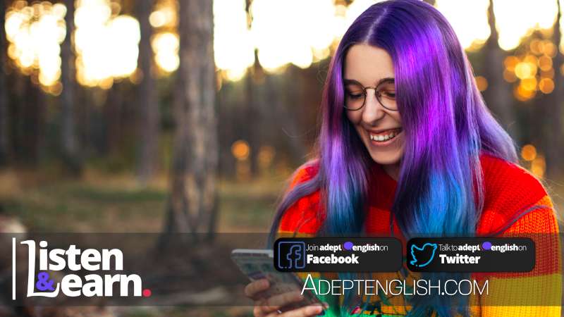 Young nerdy woman with purple hair using her smartphone and smiling. English speaking practice lesson talking about people who are on the autism spectrum.